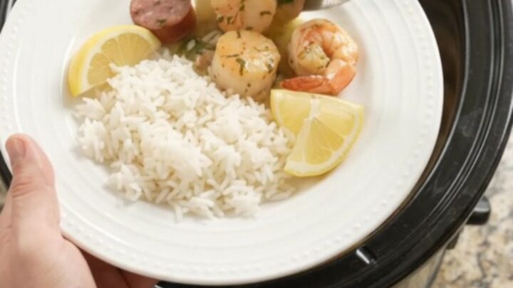 Slow cooker herb butter seafood boil with scallops, shrimp, and Andouille sausage in a creamy butter sauce