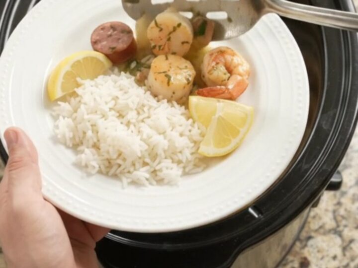 Slow cooker herb butter seafood boil with scallops, shrimp, and Andouille sausage in a creamy butter sauce