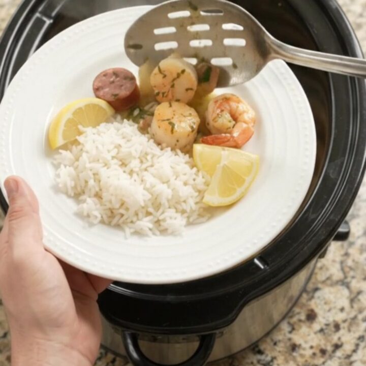 Slow cooker herb butter seafood boil with scallops, shrimp, and Andouille sausage in a creamy butter sauce