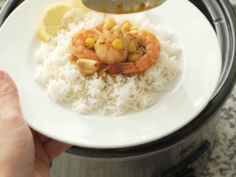 Crockpot with bayou butter garlic corn sea scallops, bubbling in crimson sauce