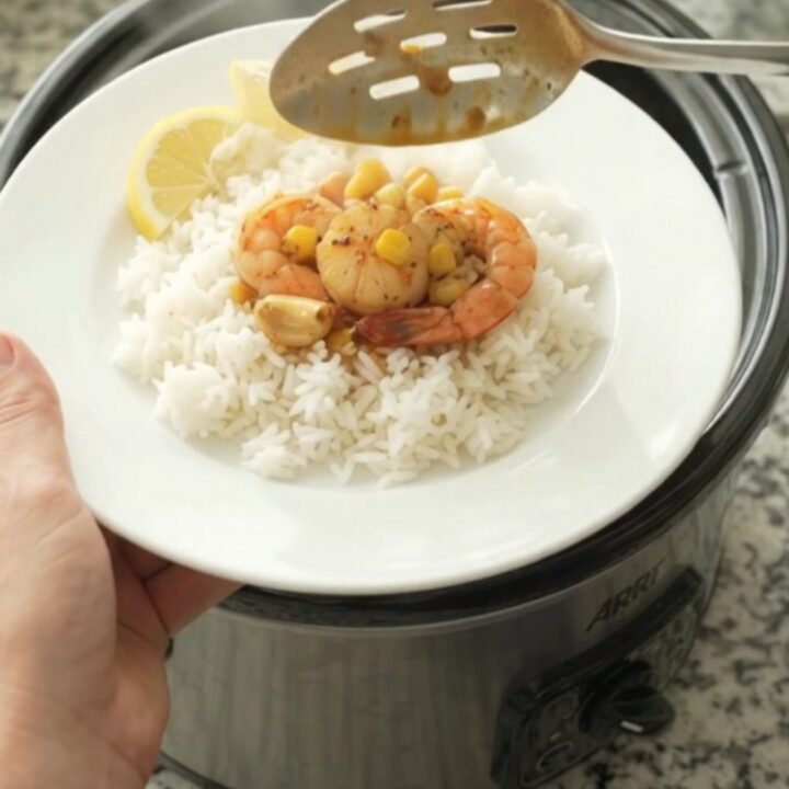 Crockpot with bayou butter garlic corn sea scallops, bubbling in crimson sauce