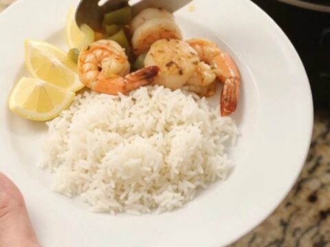 Slow cooker filled with sea scallops and shrimp in a crimson Cajun butter sauce with bell peppers and onions.
