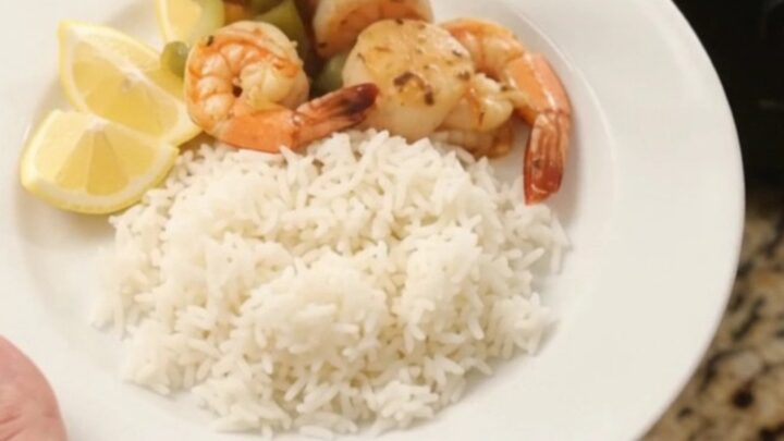 Slow cooker filled with sea scallops and shrimp in a crimson Cajun butter sauce with bell peppers and onions.