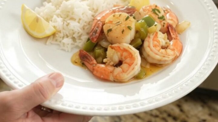 Slow cooker chili lime butter sea scallops and shrimp with bell peppers and onions, glistening in a glossy sauce.