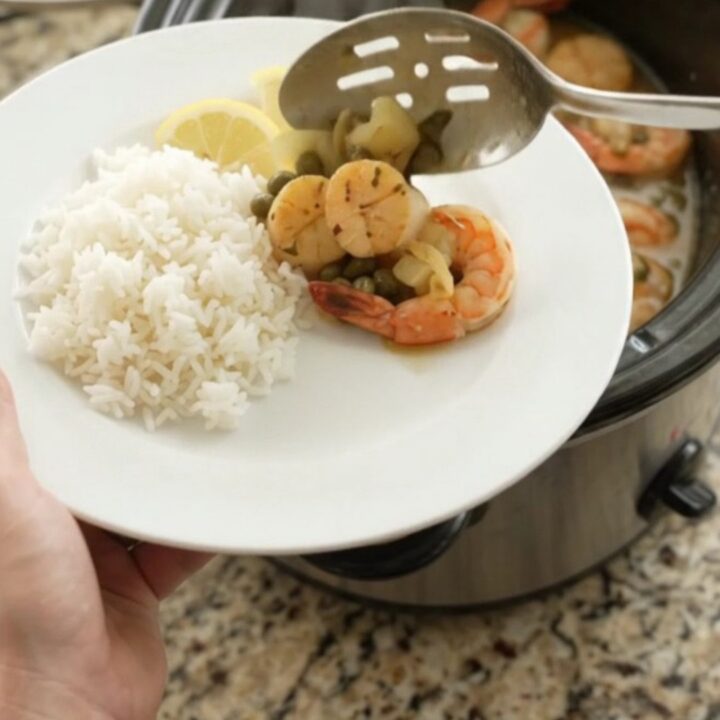 Slow cooker chili lime butter sea scallops and shrimp with lemon and capers in a glossy sauce.