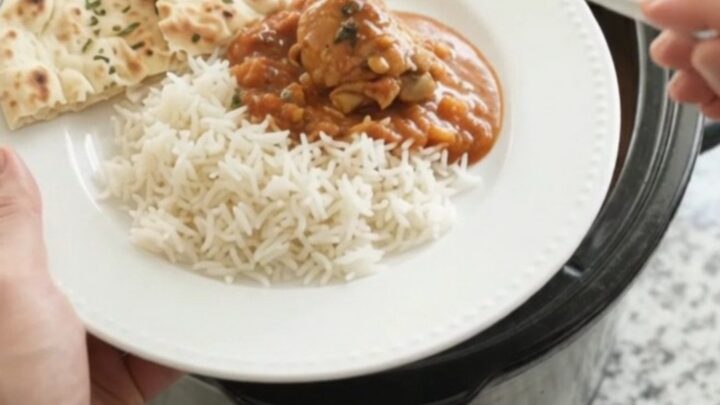 Slow cooker full of creamy tikka masala chicken with garlic herb butter