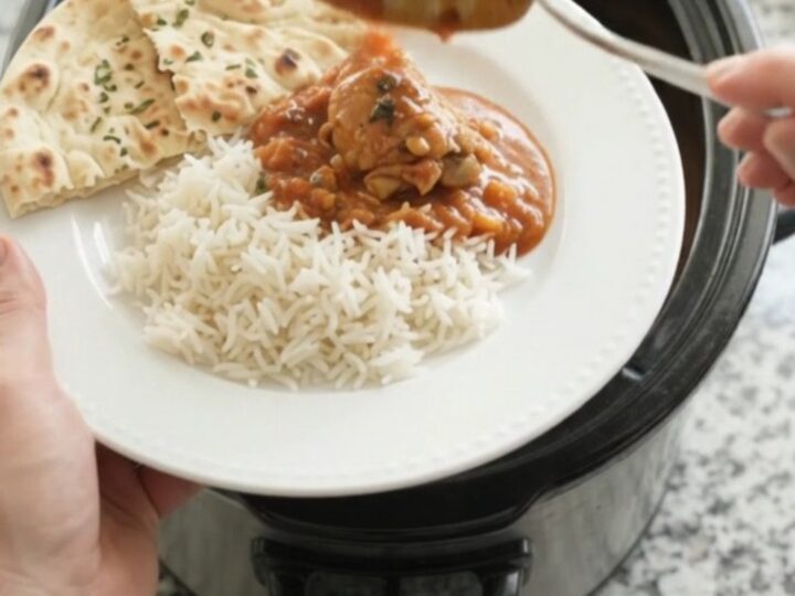 Slow cooker full of creamy tikka masala chicken with garlic herb butter