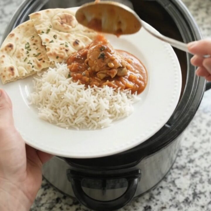 Slow cooker full of creamy tikka masala chicken with garlic herb butter