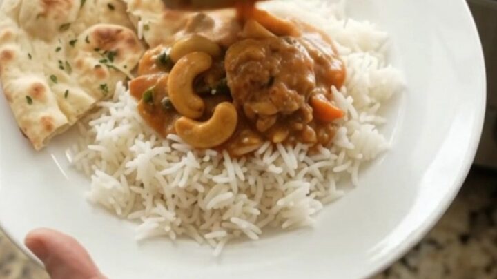 Slow cooker filled with red curry chicken thighs and creamy sauce