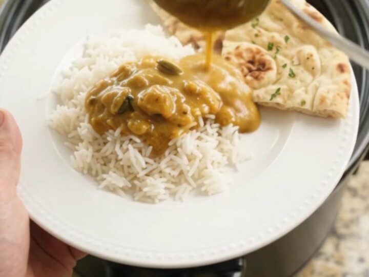 Golden korma chicken thighs in a slow cooker with coconut cream sauce and cilantro