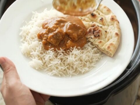 Slow-cooker makhani lamb with orange-red sauce in a black crockpot