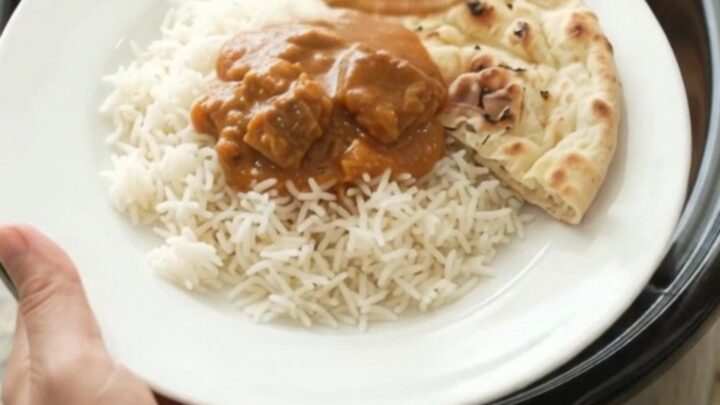 Slow-cooker makhani lamb with orange-red sauce in a black crockpot