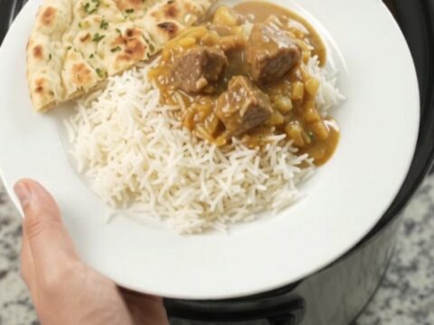 Golden korma lamb cubes in a slow cooker with creamy sauce