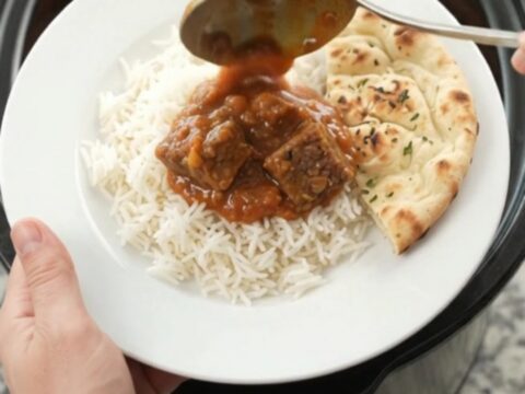 Slow cooker full of tikka masala beef brisket with creamy red sauce