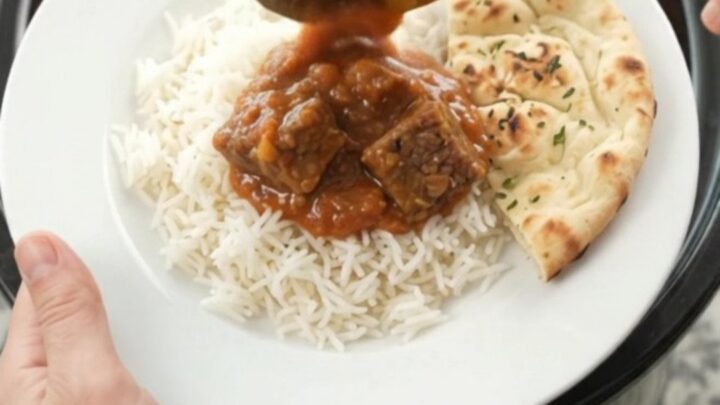 Slow cooker full of tikka masala beef brisket with creamy red sauce