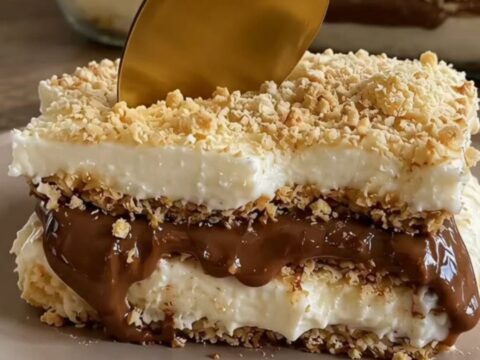 A slice of decadent Nutella coffee icebox cake on a ceramic dish with a gold spoon.
