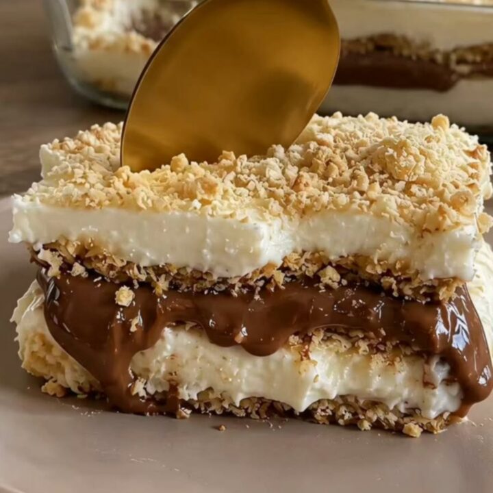 A slice of decadent Nutella coffee icebox cake on a ceramic dish with a gold spoon.