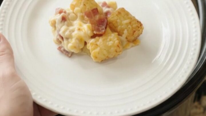 Golden tater tots and melted cheese in a slow cooker, topped with bacon and creamy sauce.