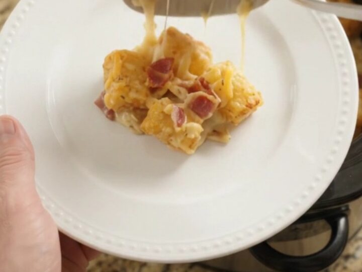 Golden tater tot bake with melted cheddar and bacon in a slow cooker