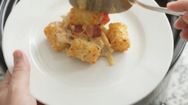 Bubbling tater tot casserole in a slow cooker with melted cheese and crispy onions