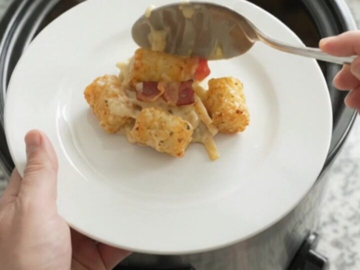 Bubbling tater tot casserole in a slow cooker with melted cheese and crispy onions