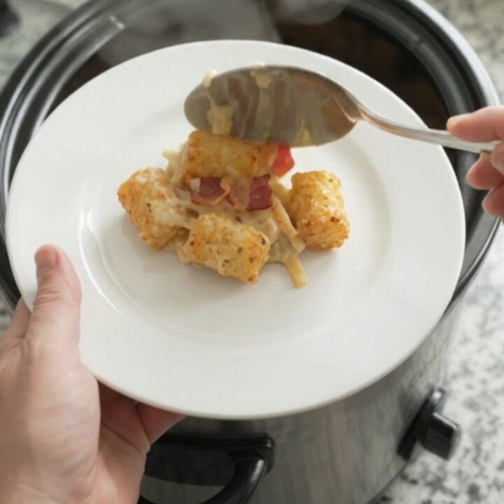 Bubbling tater tot casserole in a slow cooker with melted cheese and crispy onions