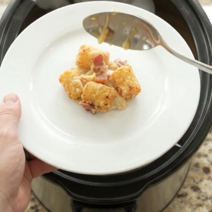 Golden tater tots and melted smoked Gouda in a slow cooker, with bacon and onions visible