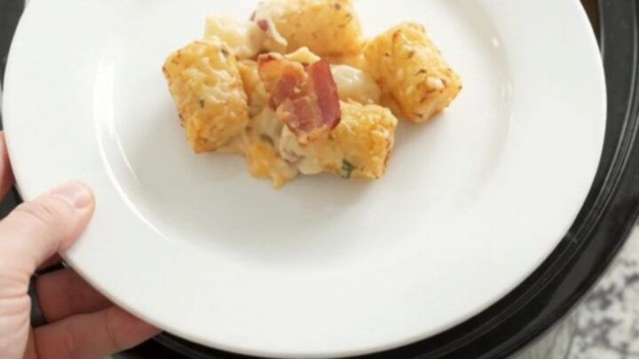 Golden tater tot bake in a slow cooker with melted cheddar and bacon