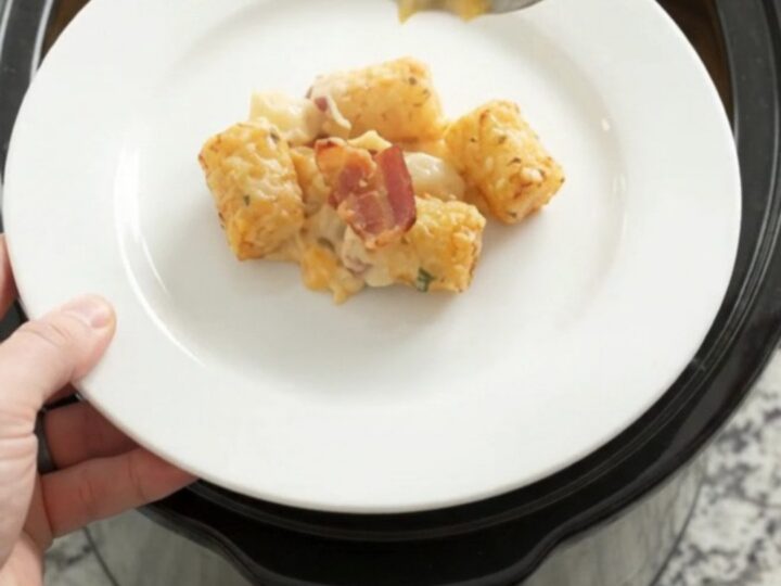 Golden tater tot bake in a slow cooker with melted cheddar and bacon
