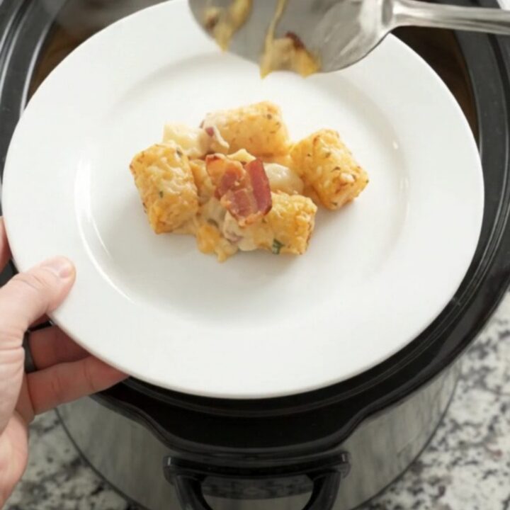 Golden tater tot bake in a slow cooker with melted cheddar and bacon