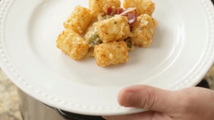 Crockpot filled with bubbling smoked Gouda green chile tater tot bake, golden and cheesy