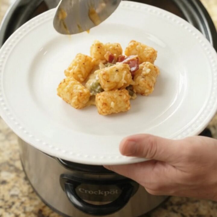 Crockpot filled with bubbling smoked Gouda green chile tater tot bake, golden and cheesy