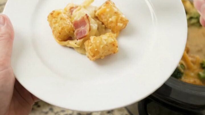 A bubbling slow cooker filled with golden tater tots, broccoli, and melted cheddar cheese.