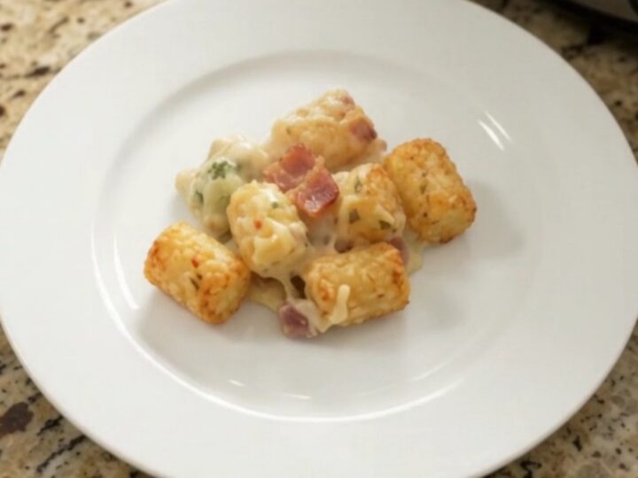 Crockpot tater tot casserole with broccoli and pepper jack cheese, golden and bubbling in the slow cooker.