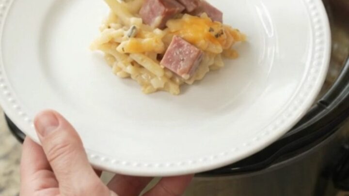 Slow cooker full of golden cheesy hashbrown casserole with melted smoked gouda and parmesan.