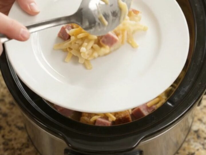 Bubbling cheddar ranch mushroom hashbrown bake in a slow cooker with melted cheese and steam rising.