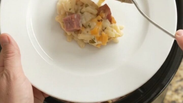 Slow-cooker hashbrown bake with melted pepper jack and crispy onions, served in a black Crockpot.