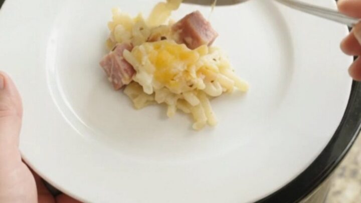 A bubbling Crockpot full of creamy hashbrown bake topped with melted smoked Gouda and Parmesan.