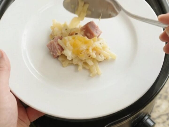 A bubbling Crockpot full of creamy hashbrown bake topped with melted smoked Gouda and Parmesan.
