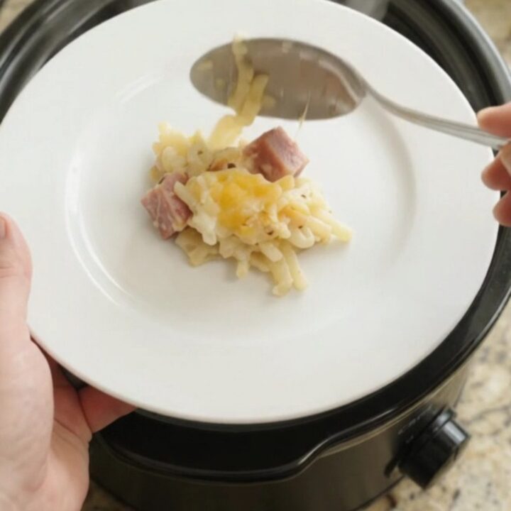 A bubbling Crockpot full of creamy hashbrown bake topped with melted smoked Gouda and Parmesan.