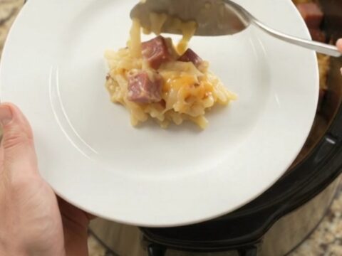 Slow cooker bubbling with cheesy hashbrown bake topped with melted smoked Gouda