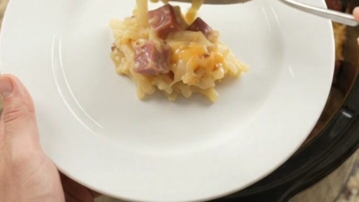 Slow cooker bubbling with cheesy hashbrown bake topped with melted smoked Gouda