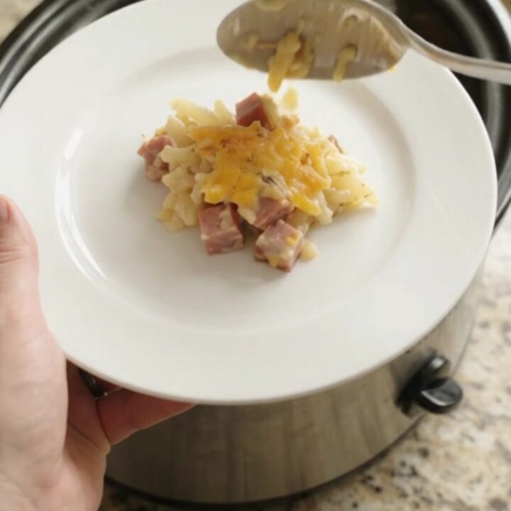 Bubbling cheddar broccoli hashbrown bake in a slow cooker with melted cheese and steam rising