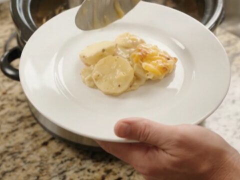 Golden cheddar crust over creamy scalloped potatoes in a slow cooker
