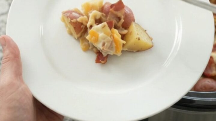 Slow cooker red potato bake with bacon, pepper jack, and crispy onions in a black Crockpot.