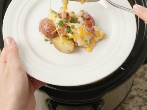 Bubbling slow cooker full of cheesy red potatoes and bacon