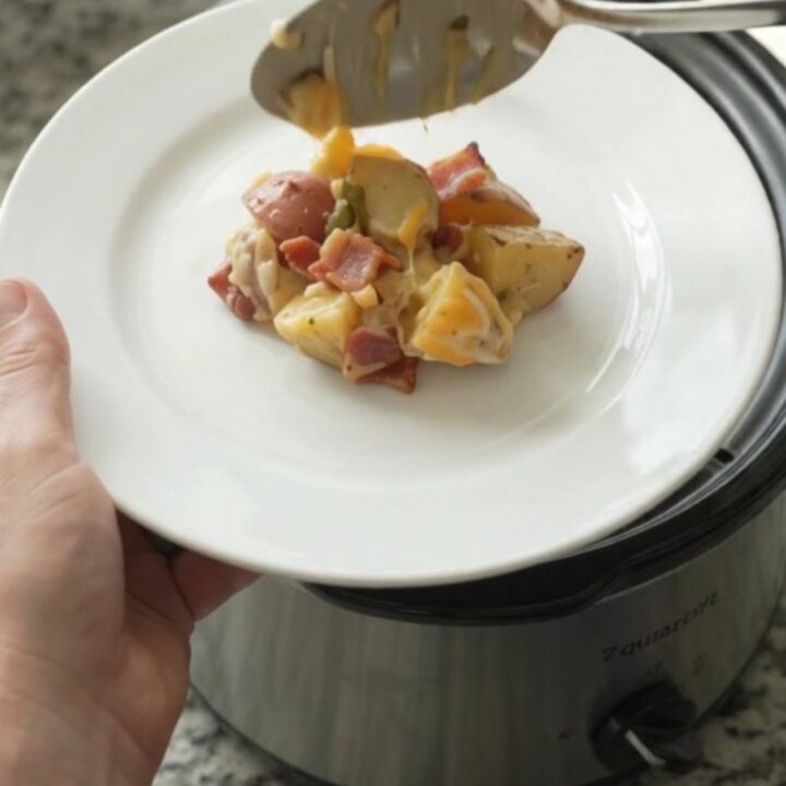 Bubbling Crockpot of Colby-Jack Green Chile Red Potato Bake with melted cheese and tender potatoes