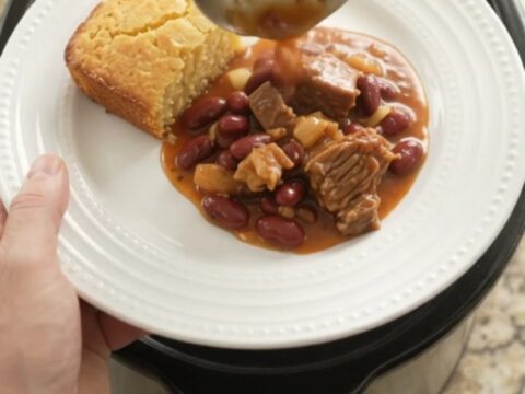 Slow cooker chili with brisket, kidney beans, and melted pepper jack cheese, topped with a creamy swirl