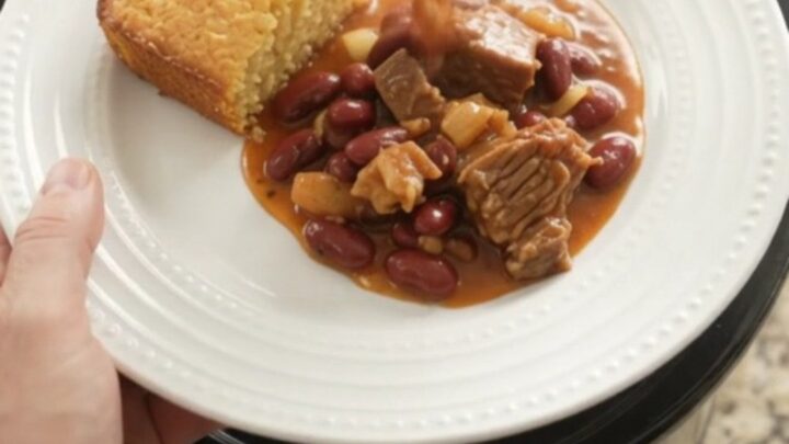 Slow cooker chili with brisket, kidney beans, and melted pepper jack cheese, topped with a creamy swirl