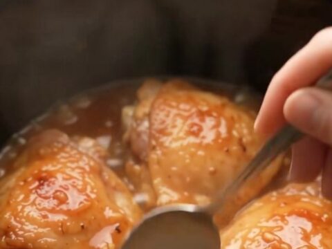 Glazed honey garlic chicken thighs in a slow cooker, coated in a shiny sauce